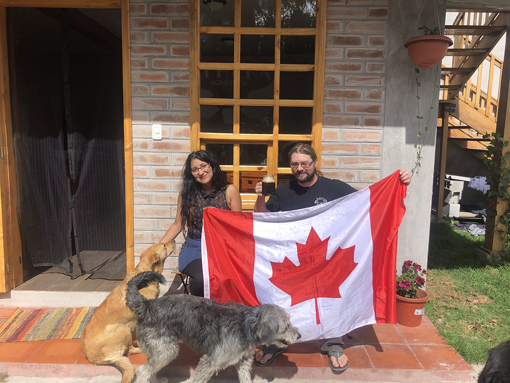 Malena and Roger with Canadian flag in front of Athena Homebrew